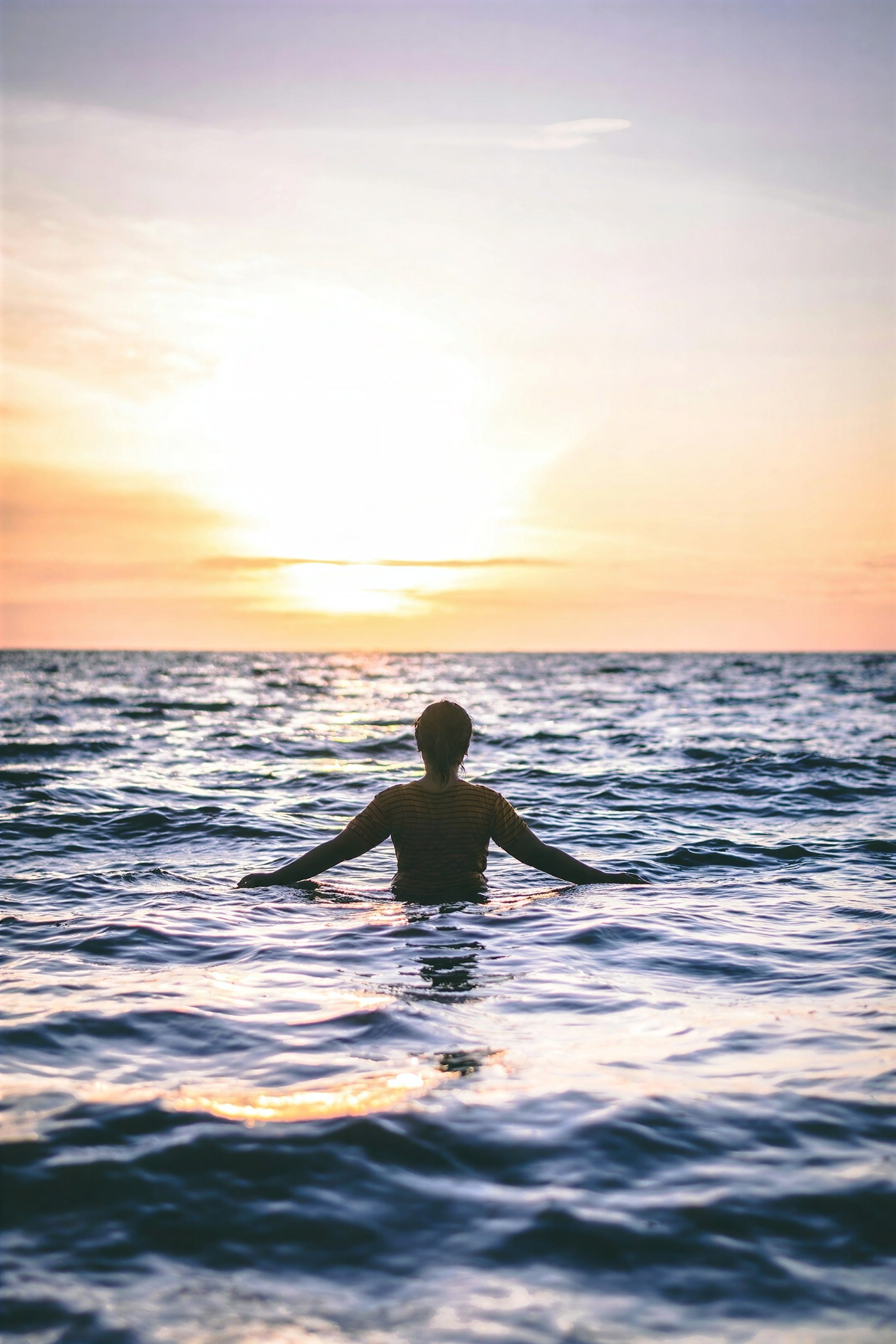 A swimmer in the sea at sunrise