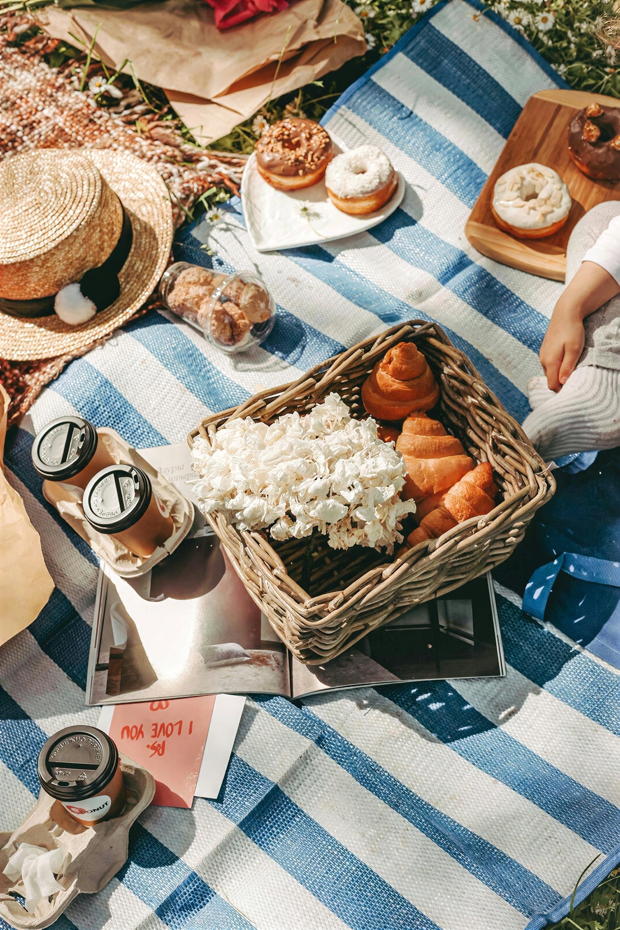 A picnic of pastries and fruit on a striped blanket
