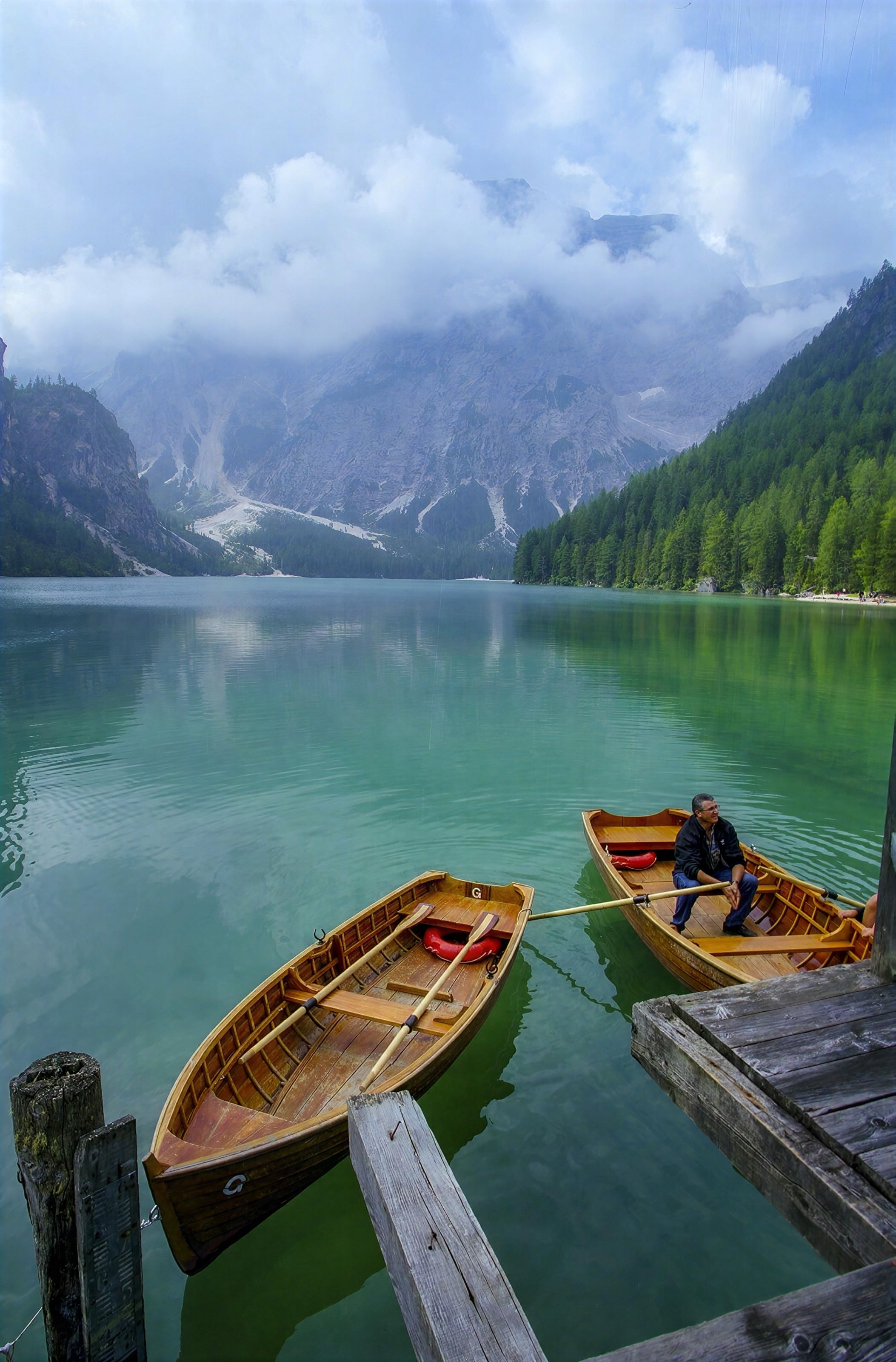 Wooden rowing boats on a turquoise lake beneath Dolomites peaks