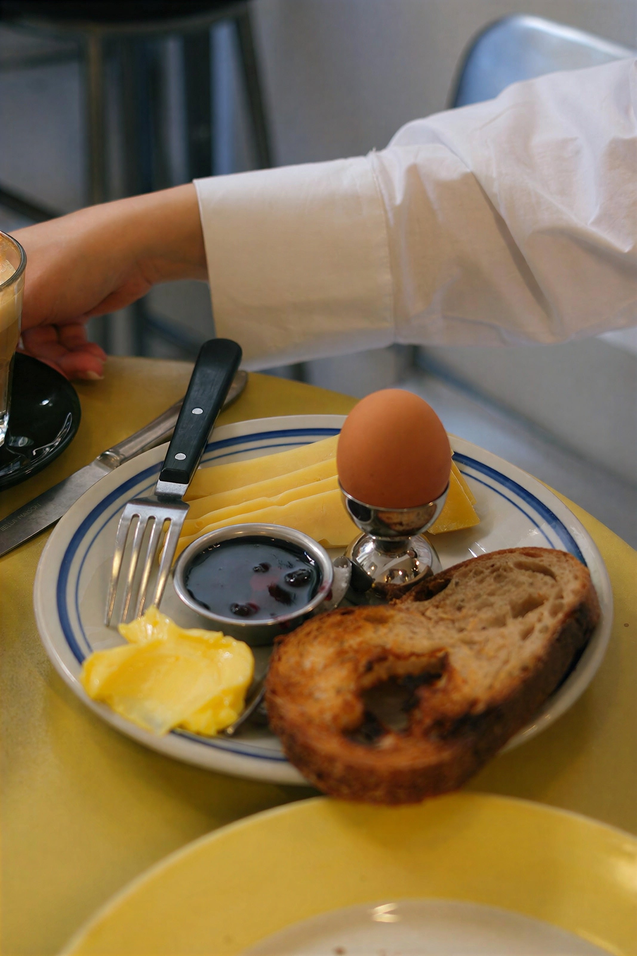 A breakfast plate with a boiled egg, toast and jam